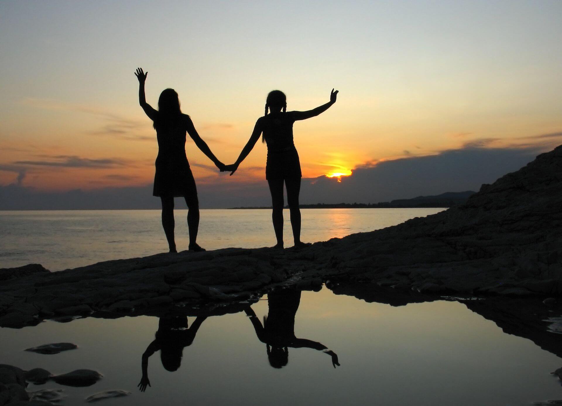 Zwei Frauen Hand in Hand bei Sonnenaufgang